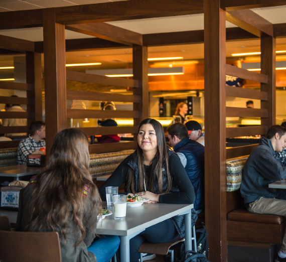 Graduating students hug each other at Commencement.